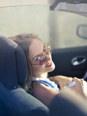 Modern woman on passenger seat in convertible